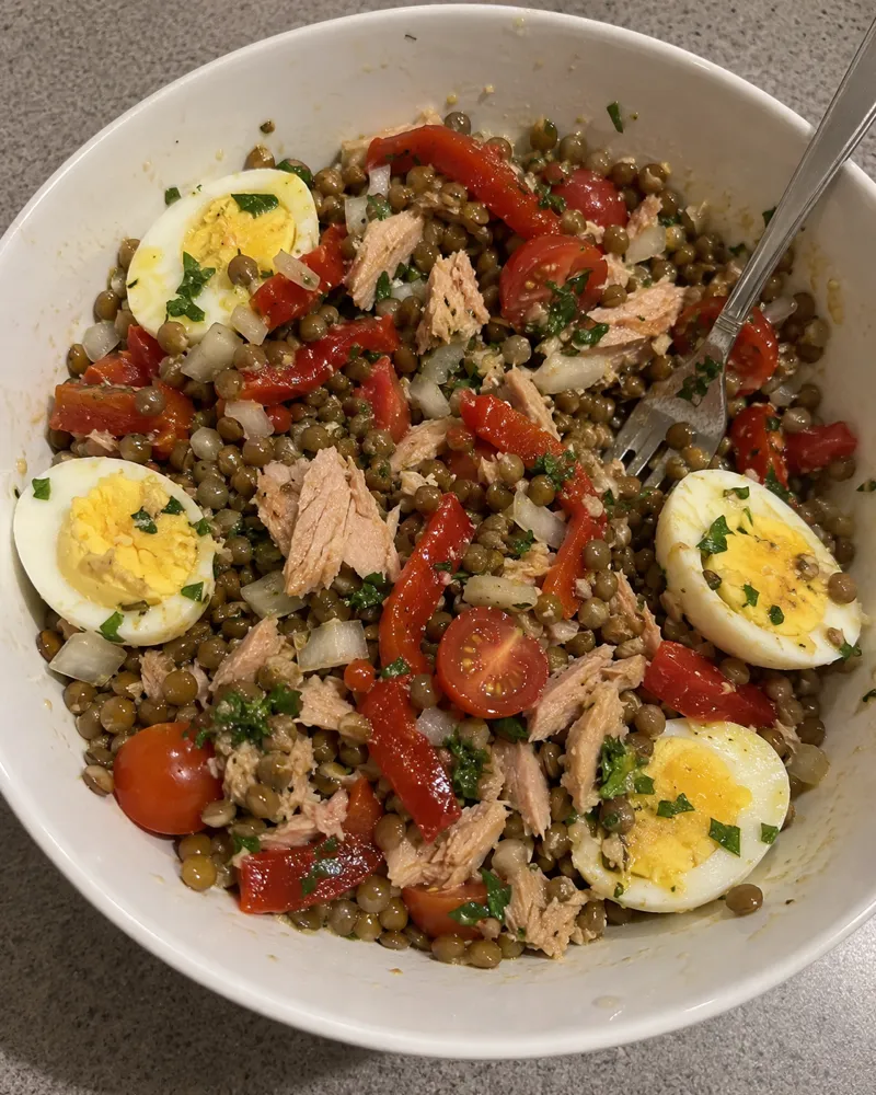 Bol de ensalada de lentejas con bonito, pimiento asado, tomate y huevo cocido