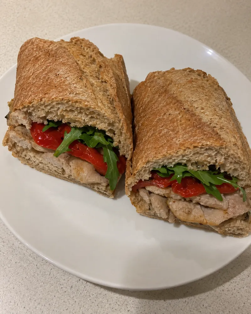 Bocadillo de pan integral con lomo a la plancha, pimientos asados y rúcula